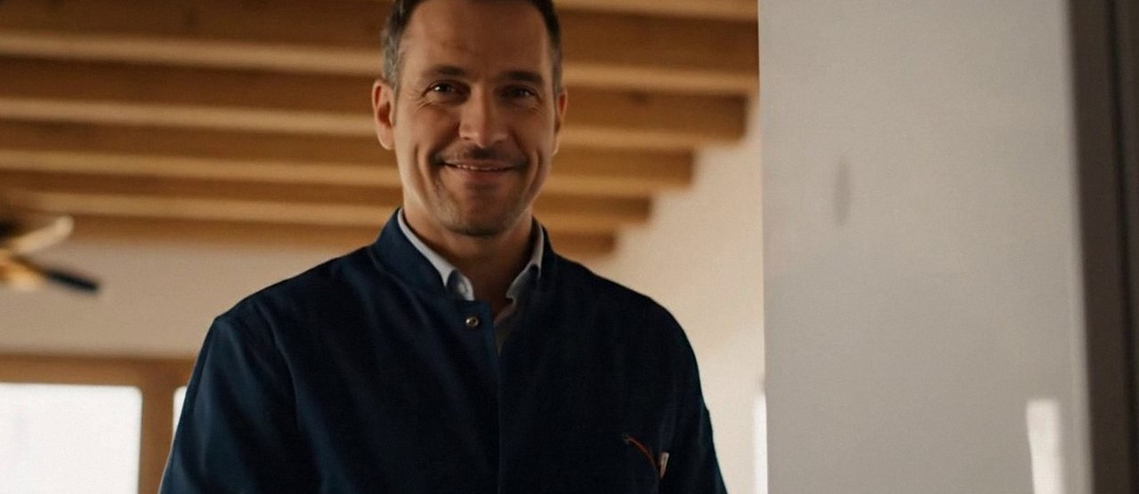 Tecnico sorridente in una casa dopo un intervento, durante il lavaggio chimico dell'impianto di una caldaia Arca a Bardolino