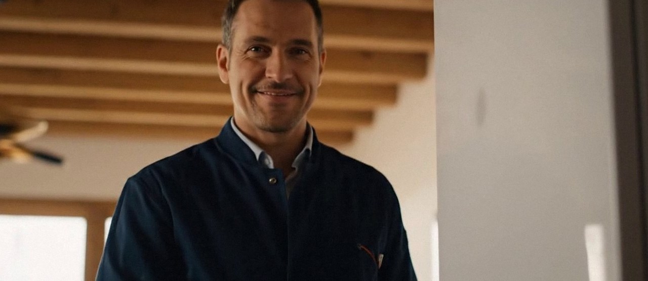 Tecnico sorridente in una casa dopo un intervento, durante il lavaggio chimico dell'impianto di una caldaia Arca a Zevio