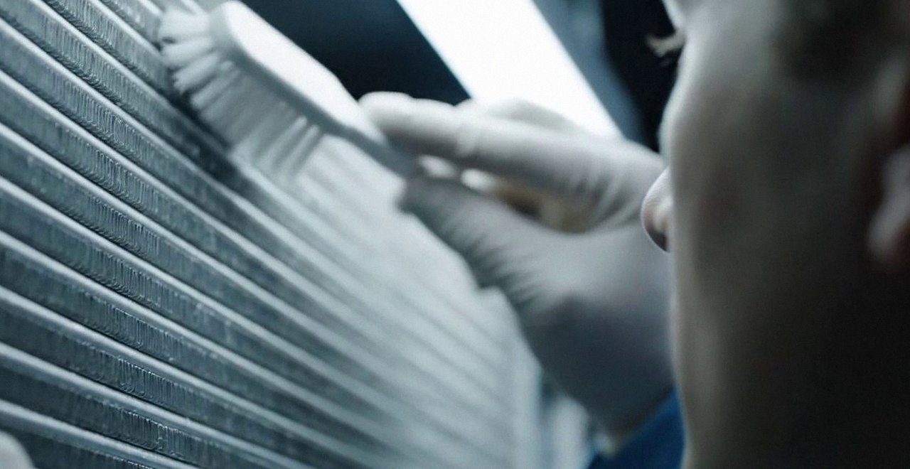 Tecnico che pulisce lo scambiatore di calore della caldaia, Verona e provincia, durante un pronto intervento di una caldaia Ariston a Caldiero