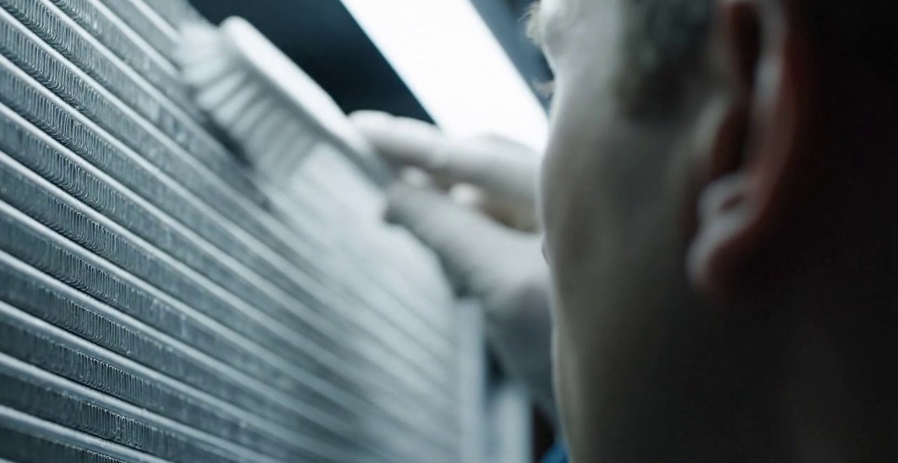 Tecnico che pulisce lo scambiatore di calore della caldaia