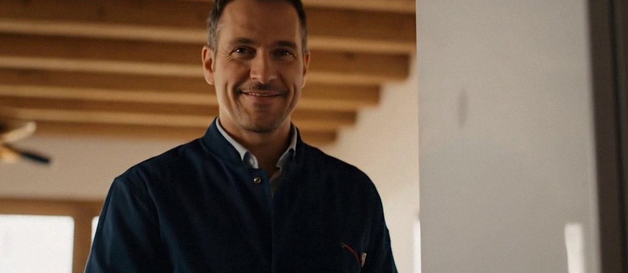 Tecnico sorridente in una casa dopo un intervento, durante il lavaggio chimico dell'impianto di una caldaia Baxi a Lavagno