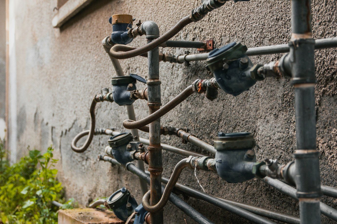 Tubazioni e contatori dell'acqua fissati a un muro