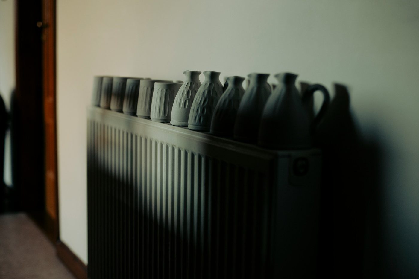 Termosifone in un soggiorno con una fila di brocche sopra