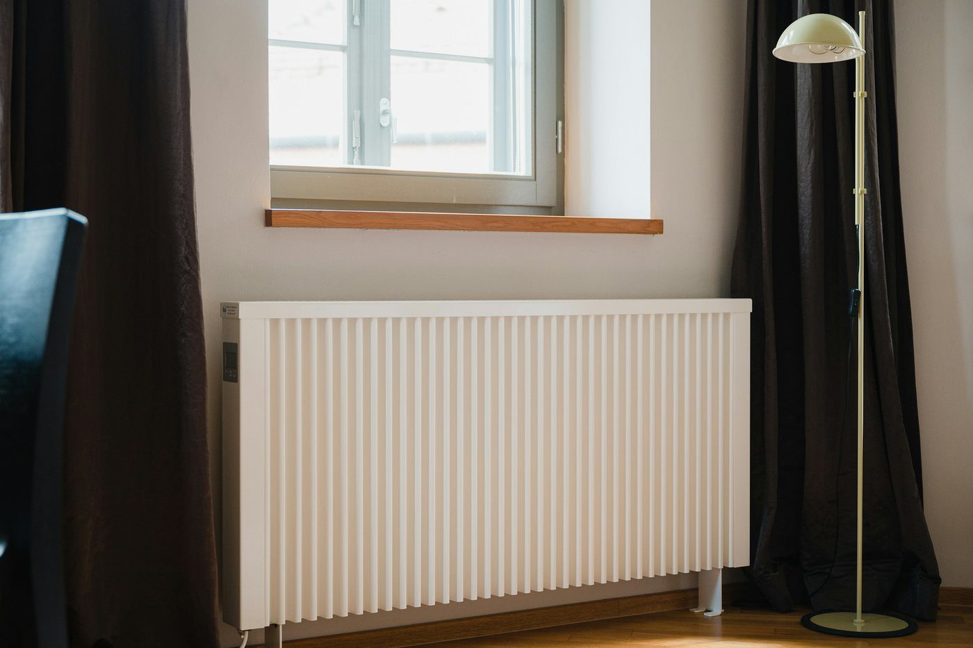 Termosifone bianco sotto la finestra di una stanza