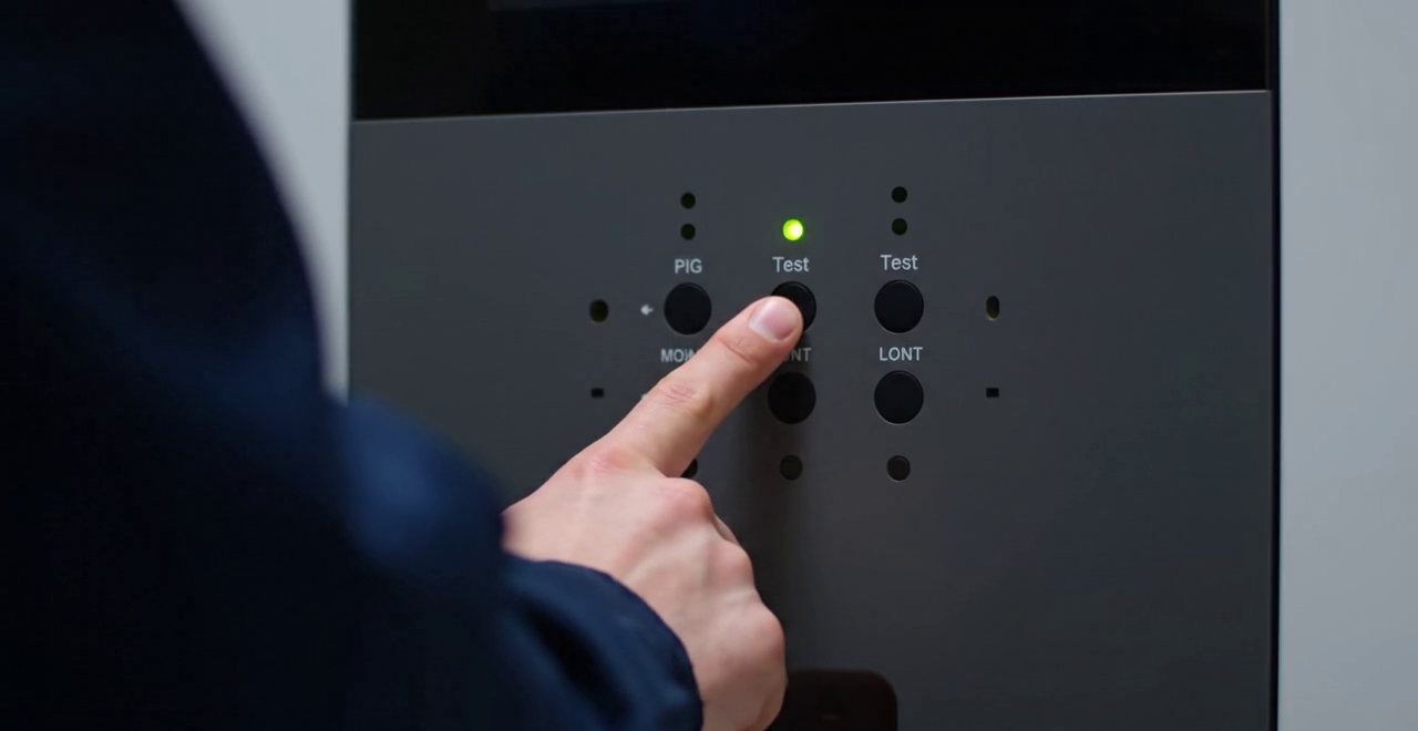 Tecnico che preme un tasto sul pannello di una caldaia