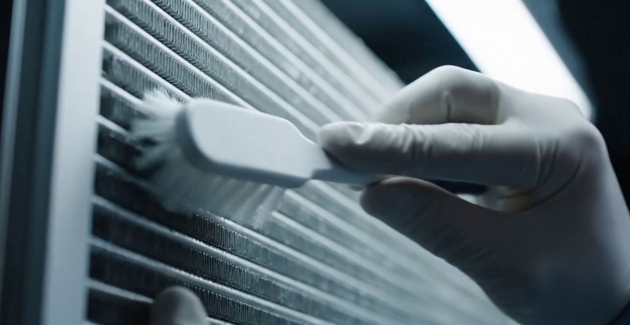 Tecnico che pulisce lo scambiatore di calore della caldaia