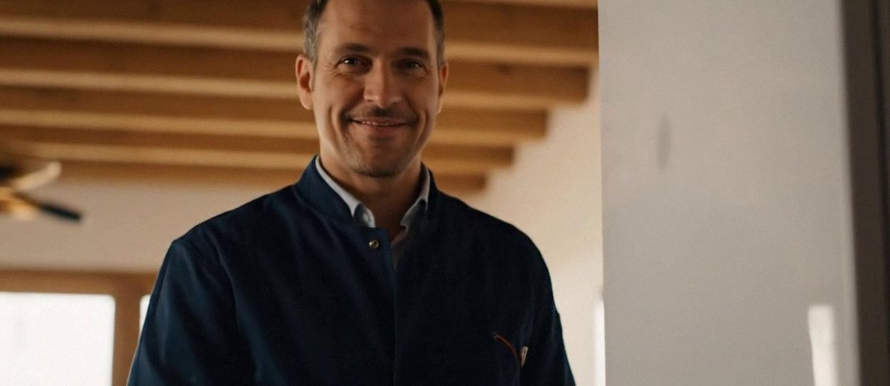 Tecnico sorridente in una casa dopo un intervento, durante il lavaggio chimico dell'impianto di una caldaia Lamborghini a Malcesine