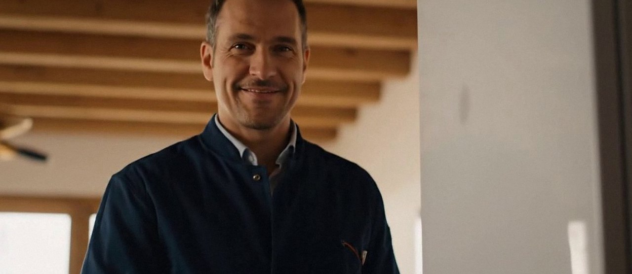 Tecnico sorridente in una casa dopo un intervento, durante il lavaggio chimico dell'impianto di una caldaia Riello a Bardolino