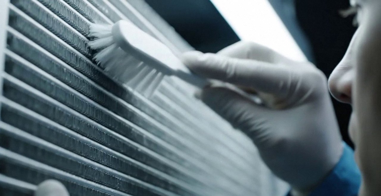 Tecnico che pulisce lo scambiatore di calore della caldaia, durante il lavaggio chimico dell'impianto di una caldaia Riello a Borgo Roma