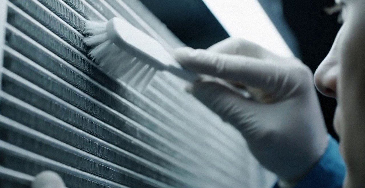 Tecnico che pulisce lo scambiatore di calore della caldaia, Verona e provincia, durante un pronto intervento di una caldaia Riello a Castelnuovo del Garda