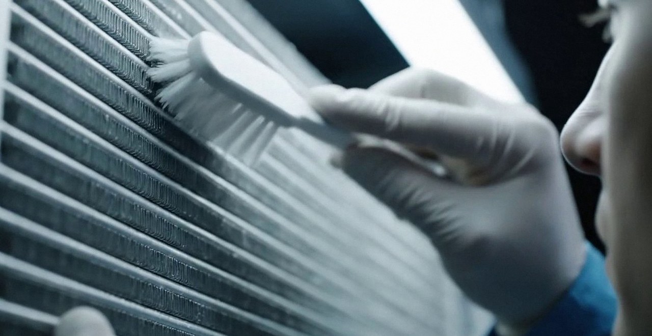 Tecnico che pulisce lo scambiatore di calore della caldaia, Verona e provincia, durante un pronto intervento di una caldaia Riello a San Pietro in Cariano
