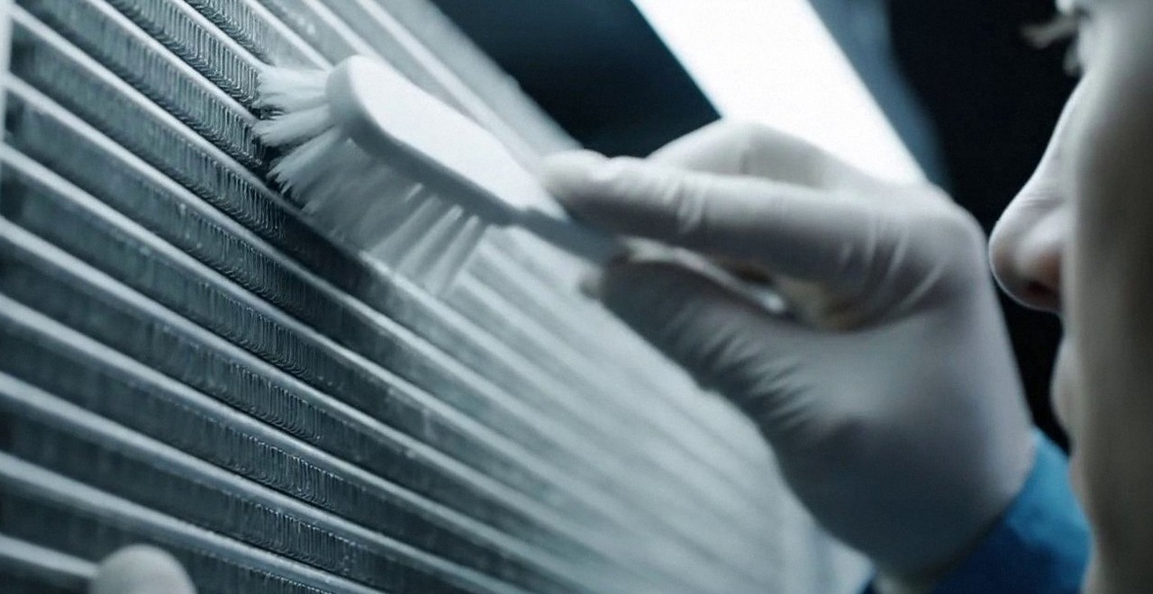Tecnico che pulisce lo scambiatore di calore della caldaia, Verona e provincia, durante un pronto intervento di una caldaia Riello a Zevio
