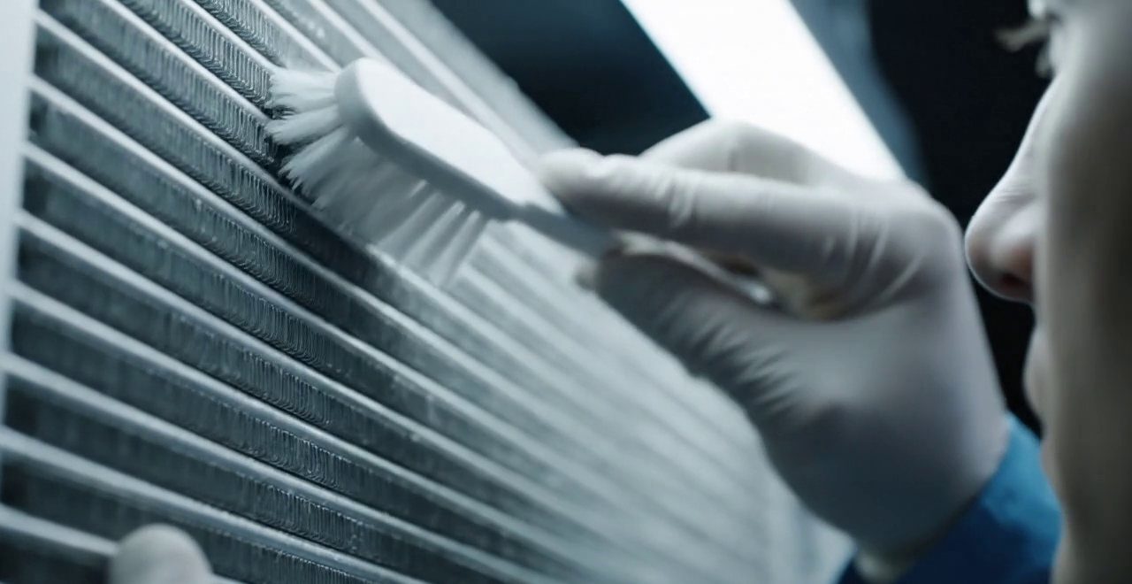 Tecnico che pulisce lo scambiatore di calore della caldaia
