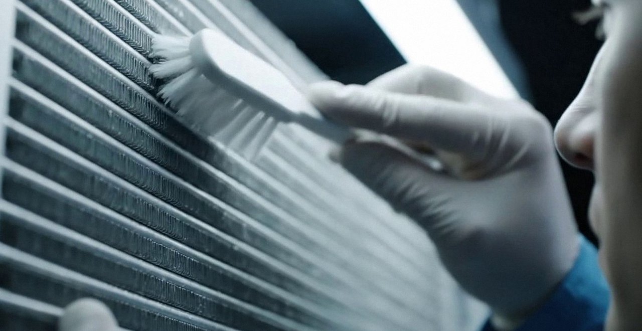 Tecnico che pulisce lo scambiatore di calore della caldaia, Verona e provincia, durante un pronto intervento di una caldaia Sime a Malcesine
